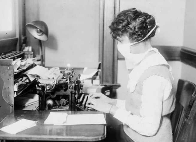 Машинистка носит маску от гриппа в октябре 1918 года